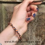 دستبند نخی طرح ضربدر رنگ مشکی و نارنجی و آبی روشن