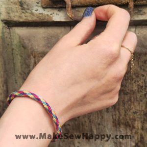 دستبند نخی طرح ضربدر رنگ صورتی و بنفش و زرد و آبی روشن