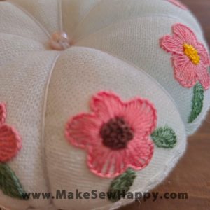 جا سوزنی پارچه‌ای طرح گل‌دوزی رنگ سفید با گل‌های صورتی