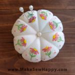 جا سوزنی پارچه‌ای طرح گل‌دوزی رنگ سفید با گل‌های صورتی و سفید