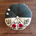 جا سوزنی پارچه‌ای طرح گل‌دوزی رنگ سفید و طوسی با گل‌های سرخ