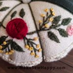 جا سوزنی پارچه‌ای طرح گل‌دوزی رنگ سفید و طوسی با گل‌های سرخ