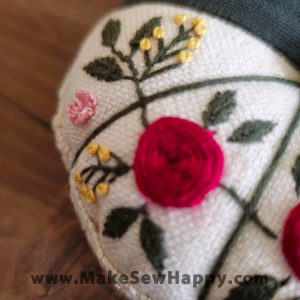 جا سوزنی پارچه‌ای طرح گل‌دوزی رنگ سفید و طوسی با گل‌های سرخ