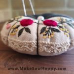 جا سوزنی پارچه‌ای طرح گل‌دوزی رنگ سفید و طوسی با گل‌های سرخ